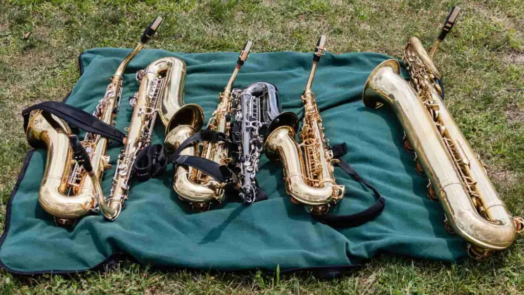 two tennor, three alto, and a bari saxiphone on a blanket