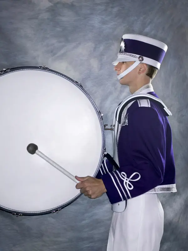 Marching bass drum player wearing uniform
