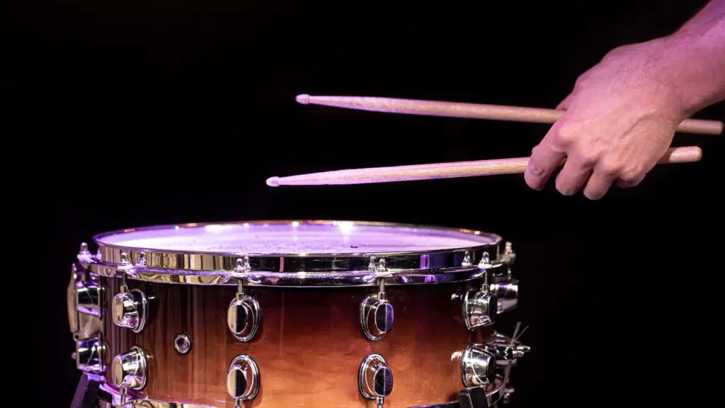 Drummer hitting drum sticks on snare drum