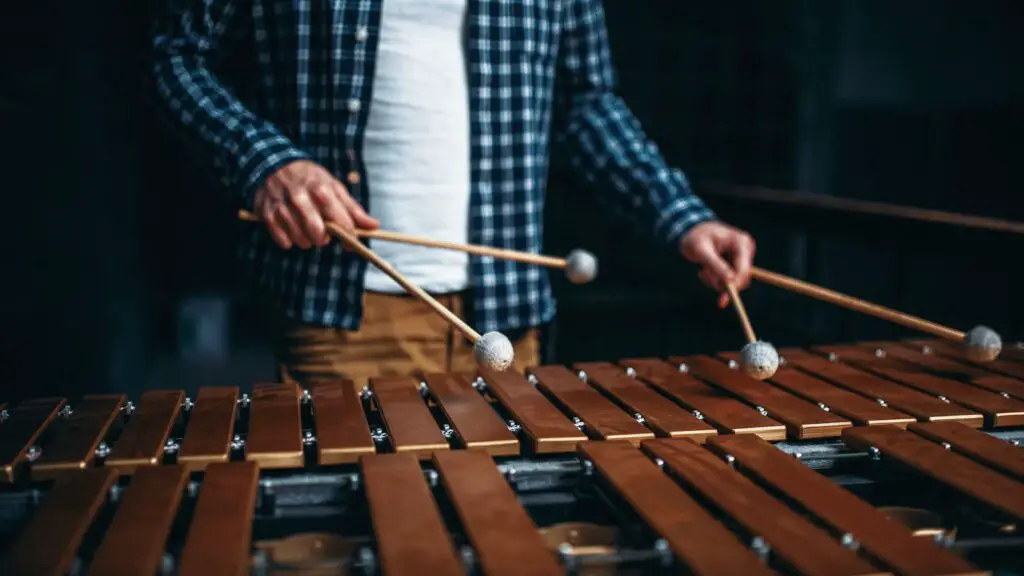 musician playing xylophone with 4 mallets
