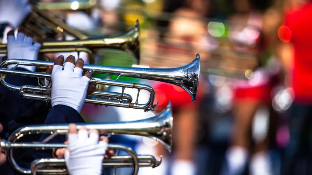 Brass instruments held with white gloves on a blurry background