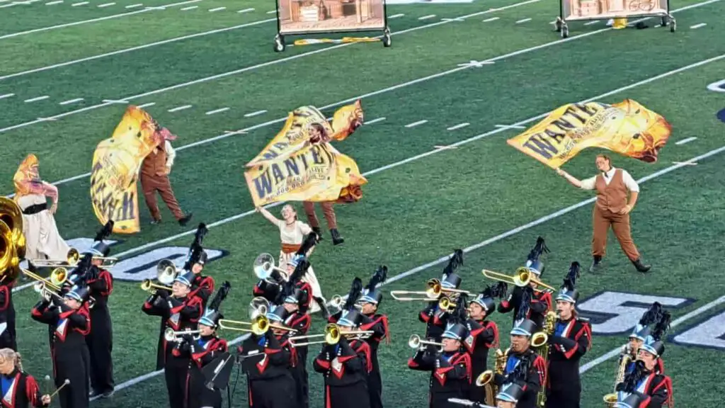 Marching band and color guard performing for a competition.