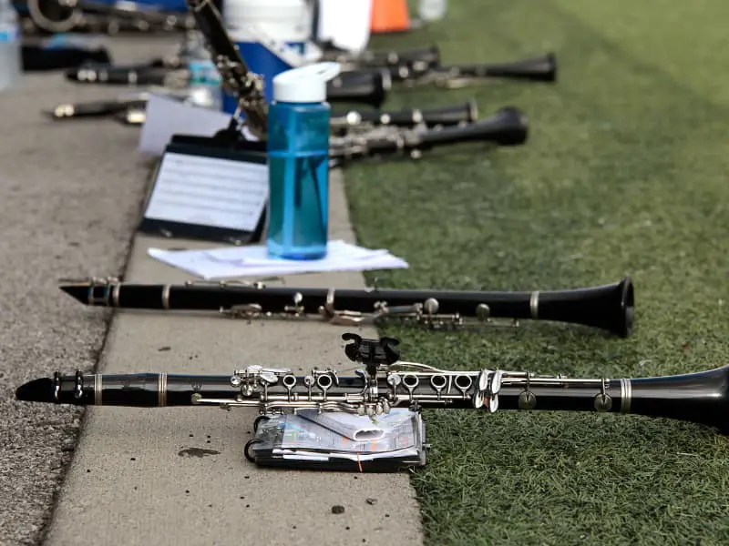 Clarinets with lyres lying on turf near water bottles at marching band camp. 