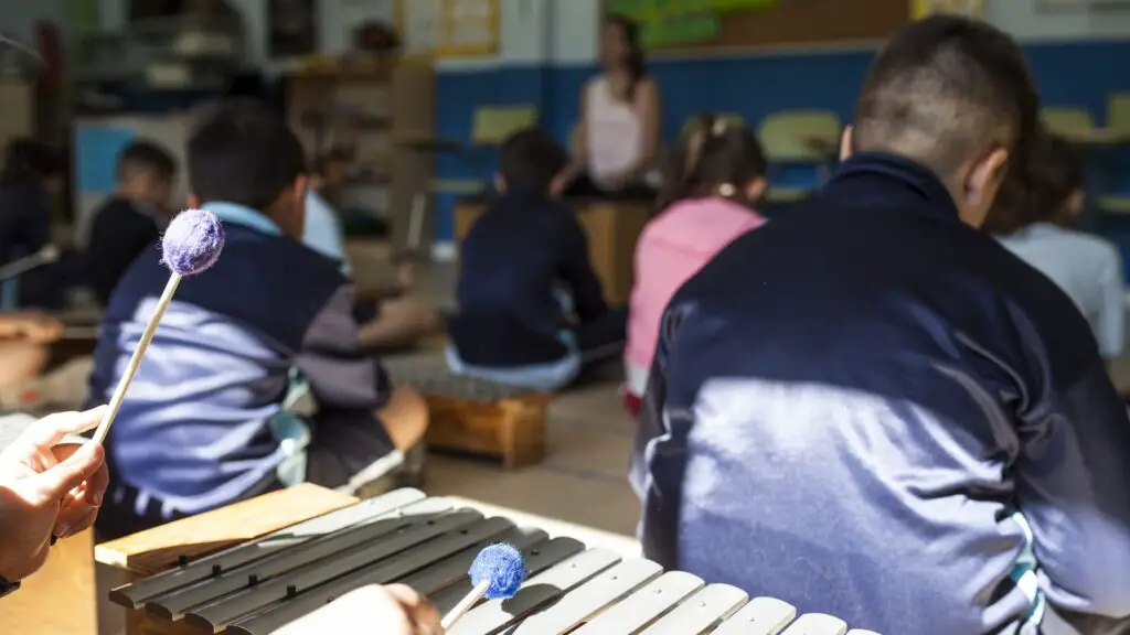 Classroom full of school children learning to play the xylophone