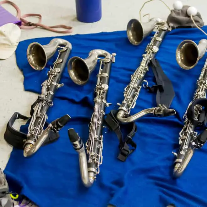 marching bass clarinets laying in a line on a blue blanket on the ground